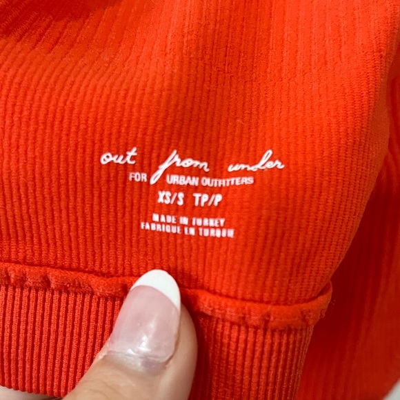 This is a red stretchy tank top with a cut in the stomach. - Picture 3 of 3